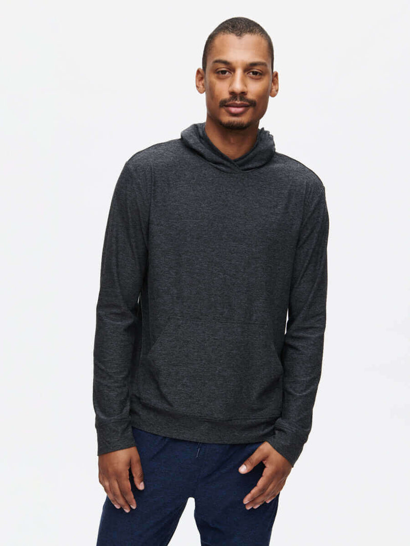 Model wearing a CloudKnit Hoodie in dark grey, featuring a large kangaroo pocket and a lightweight design.