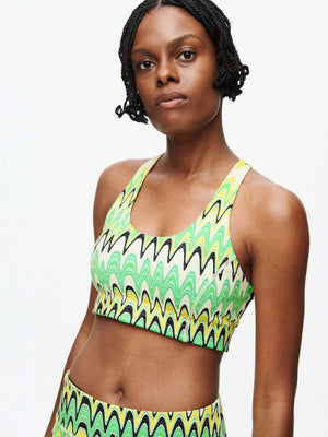 Model showcasing the vibrant Doing Things Bra CL in green and black wavy pattern.