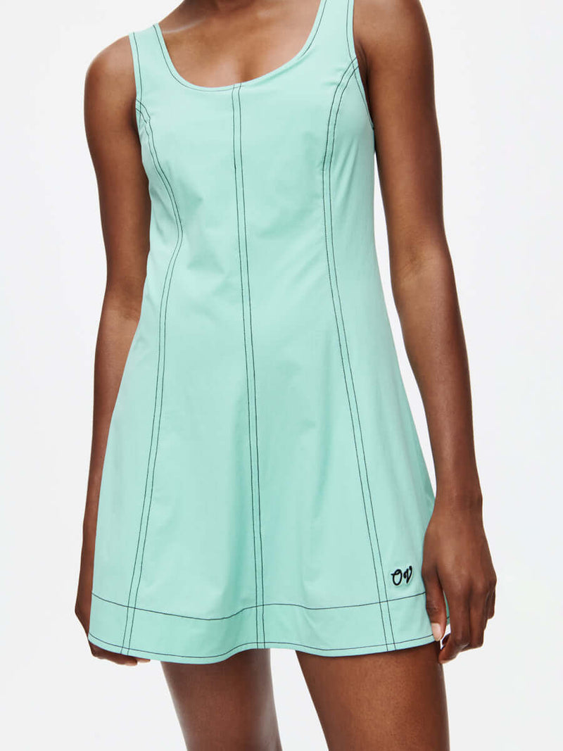 Woman wearing the Energy Dress in mint with A-line silhouette and contrast stitching, perfect for movement.
