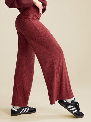 a woman wearing a pair of dark red pants
