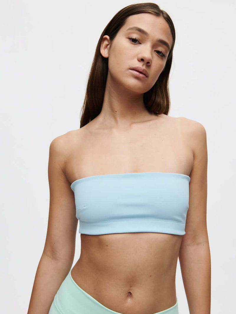 A model showcases the Love Bra, a low-impact bandeau top in soft Bubble Wrap fabric, perfect for movement.