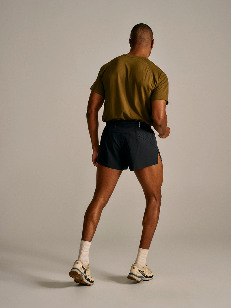 a person wearing a green shirt and black shorts