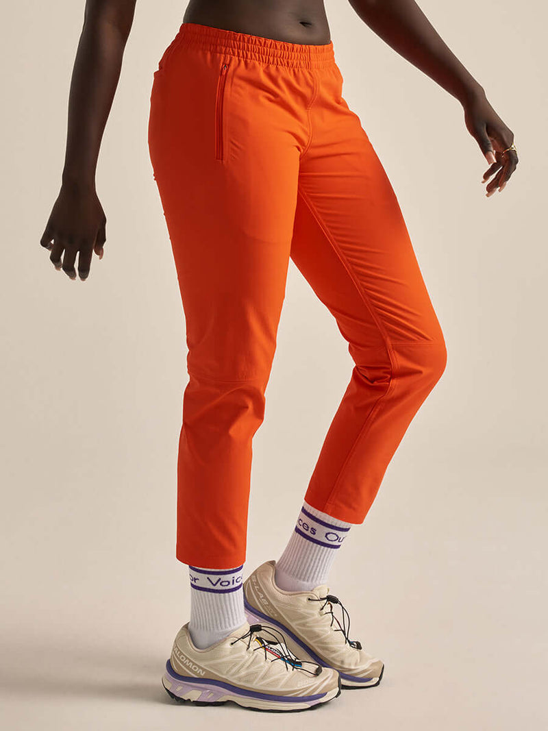 Model wearing bright orange RecTrek 26" Pant CL, showcasing comfort and style for outdoor adventures.
