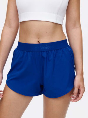 A model wearing Relay 3" Short in blue, showcasing the lightweight design and elastic band for active wear.