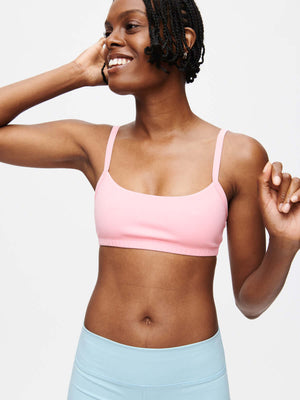 Model wearing a pink Solar Bra with adjustable straps in a bright and cheerful pose.