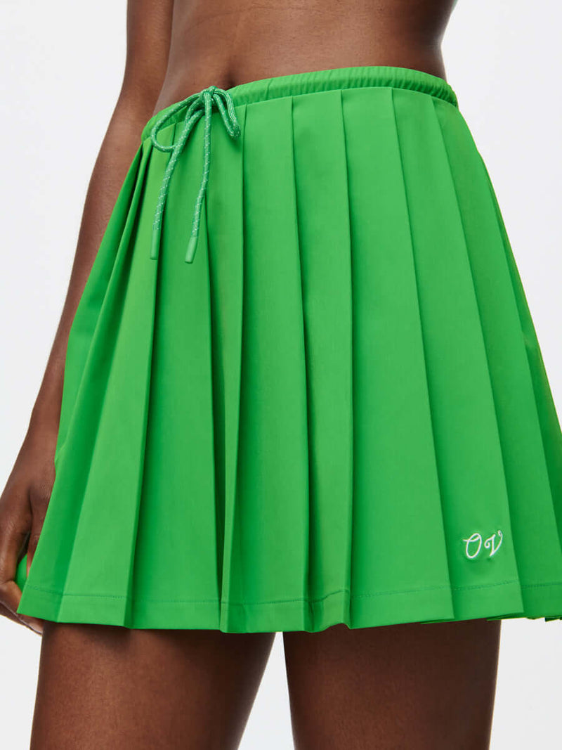 A vibrant green Stardust Skirt with pleats, side zipper, and drawstring tie, designed in lightweight fabric.