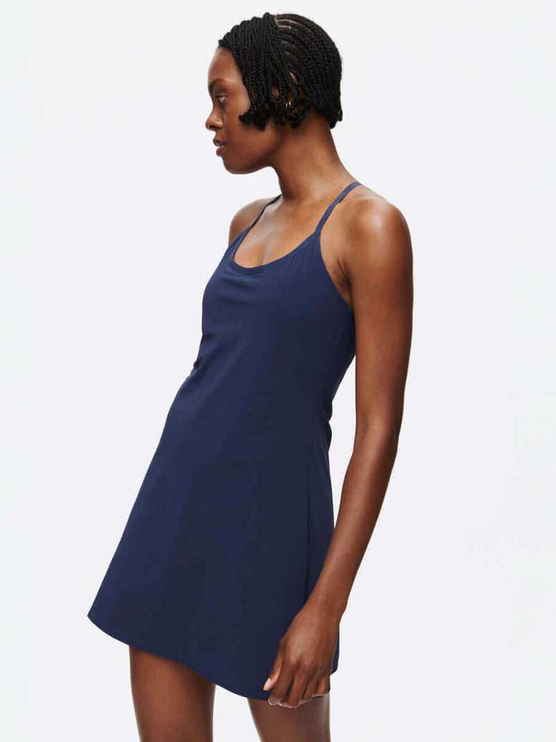 Model wearing The Exercise Dress in navy, showcasing its sporty design and adjustable straps.
