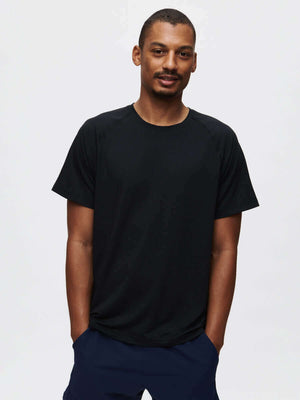 Model wearing ThinkFast Mesh Shortsleeve in black, showcasing its classic fit and high-performance cooling technology.