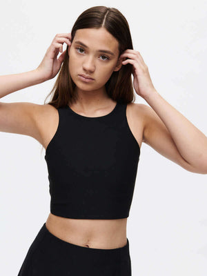 Model wearing a Venus Crop Top, showcasing its cropped silhouette and sleek design in a classic black color.