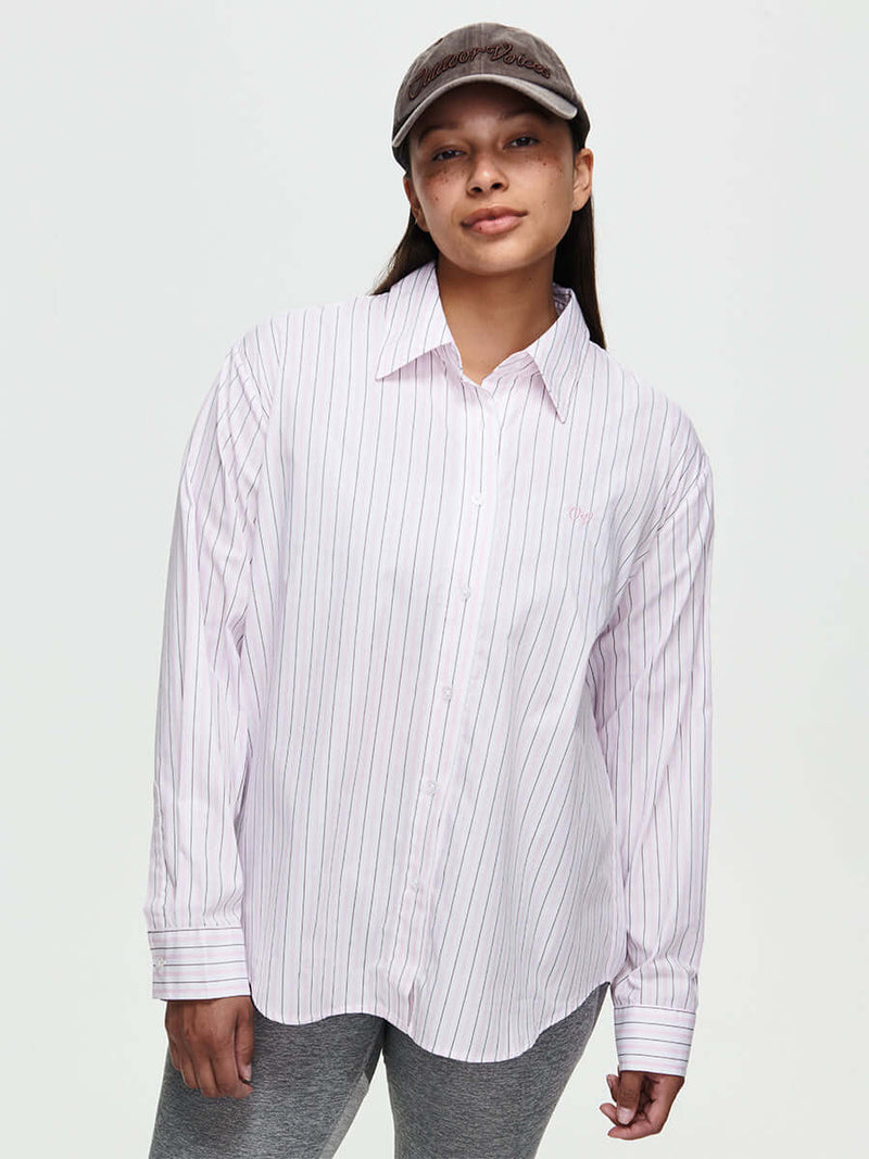 Model wearing a Striped Sun Shirt, an oversized button-up in lightweight cotton with subtle stripes.