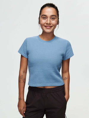 Waffle Baby Tee CL displayed on a smiling model in a light blue color, perfect for casual wear and comfort.