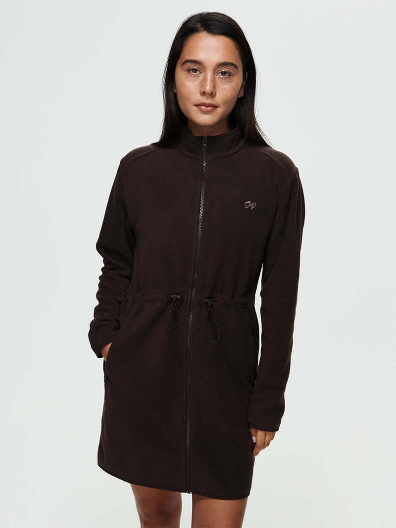 Model wearing the Boulder Dress, a long-sleeve, full-zip dress with adjustable waist toggles and front pockets.