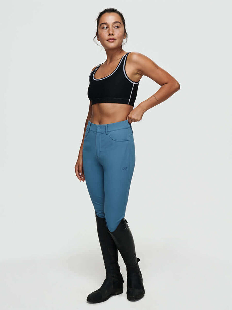 Woman wearing stretchy riding gear showcasing the Ride Pant, perfect for comfort and durability while riding.