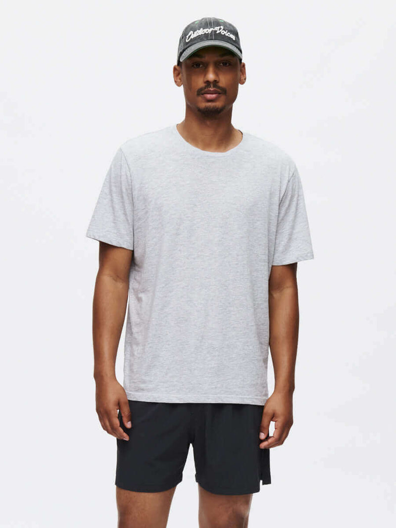 Man wearing a grey shirt and black shorts showcasing the Zephyr 5" Short with casual style.